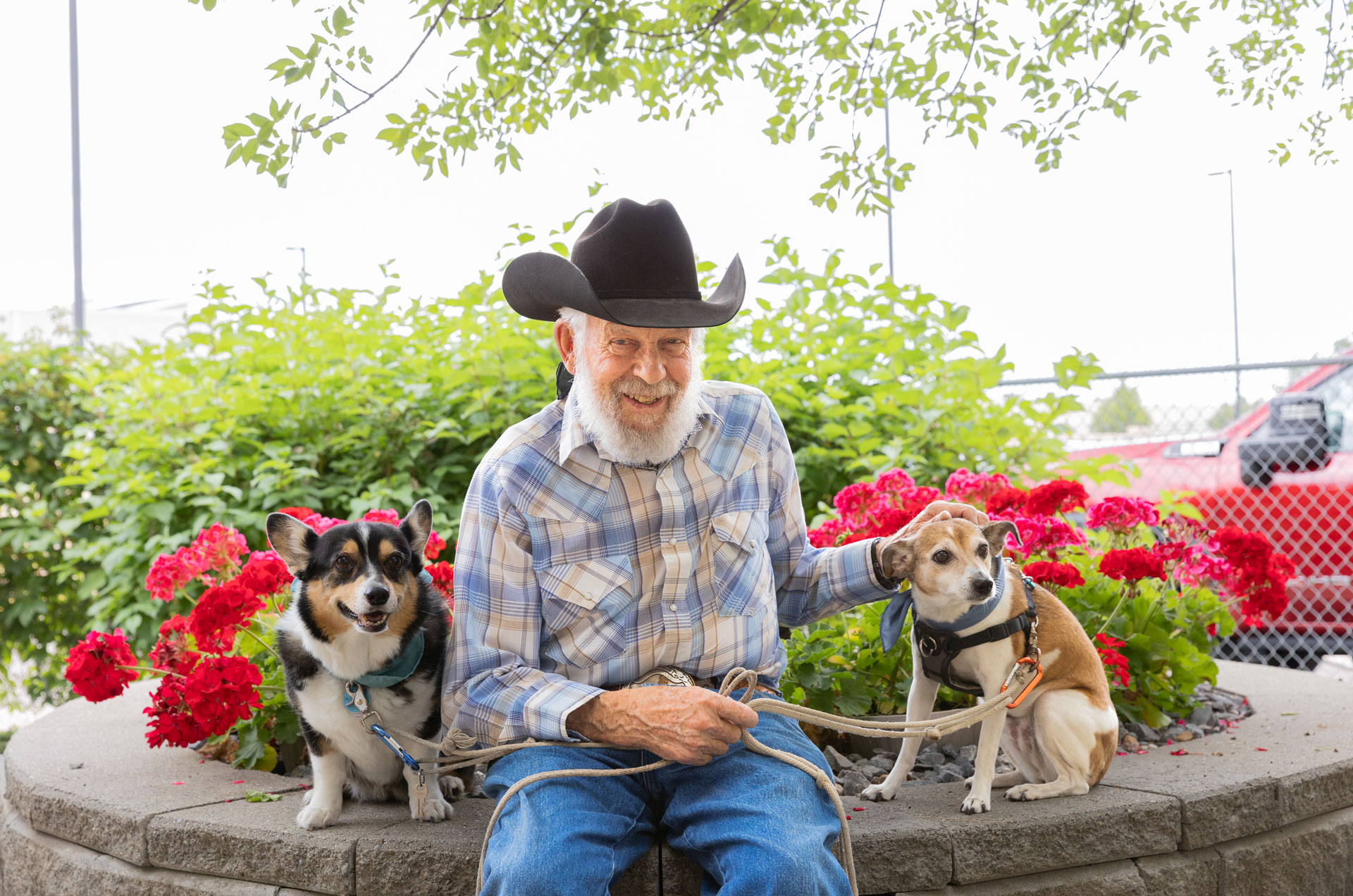 resident sitting with two dogs outside
