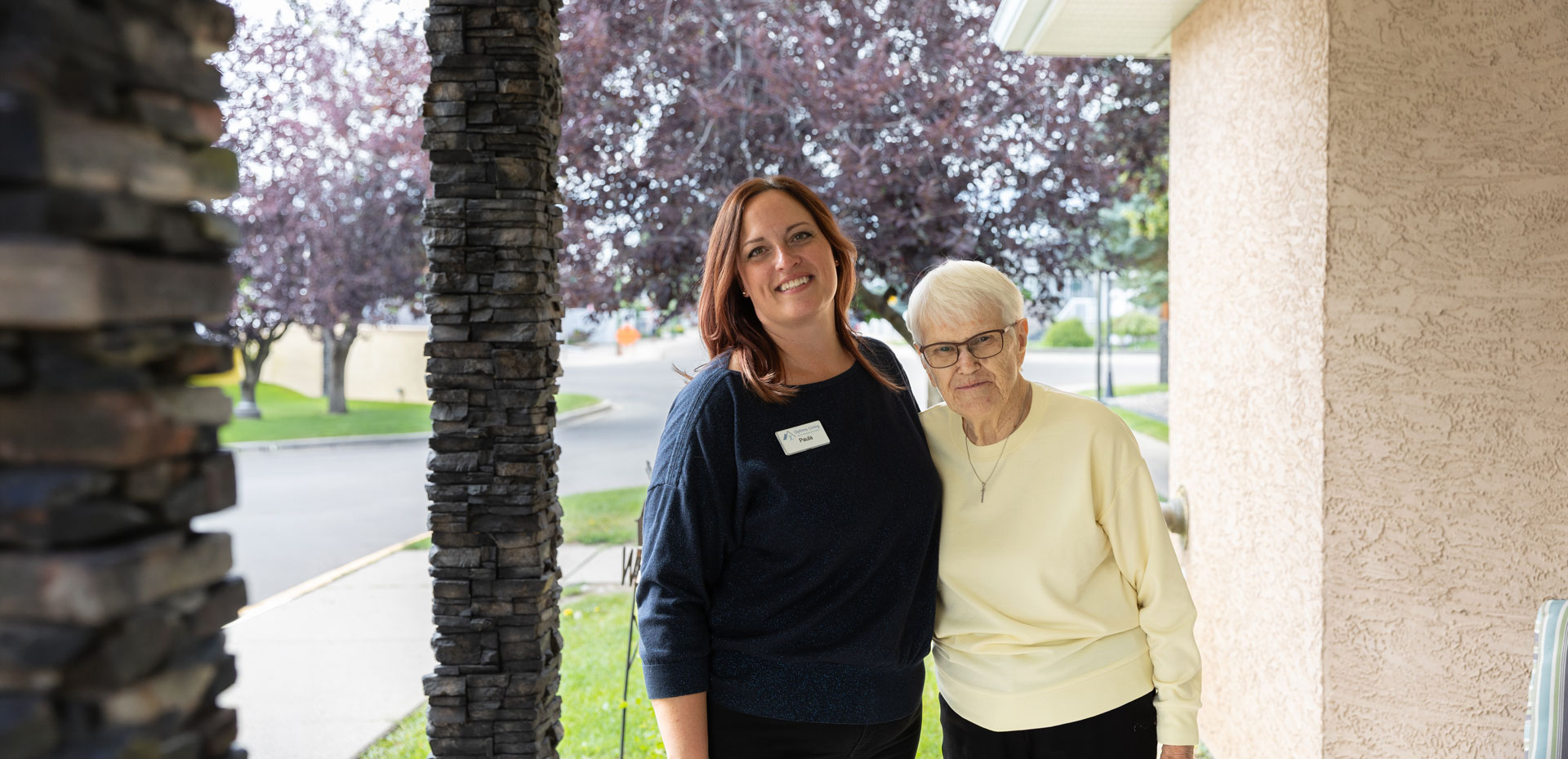 team member and resident smiling outside