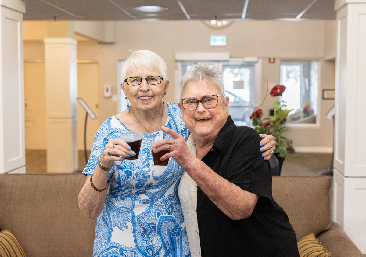 two residents smiling and drinking iced tea